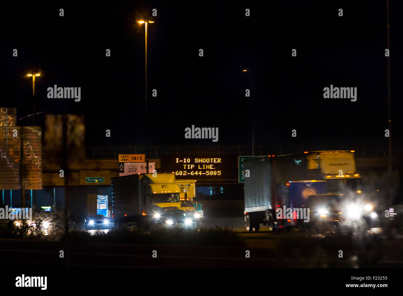 Les automobilistes sur l'I-10 à Phoenix passent des panneaux lumineux avertissant d'un tireur de l'I-10 et affichant une ligne de pointe de police pour information. Banque D'Images