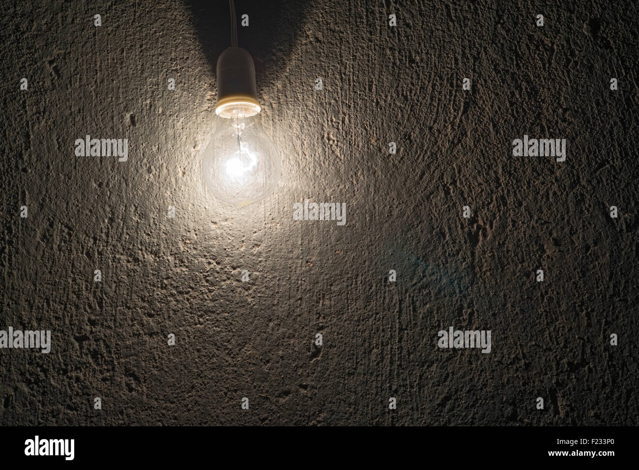 L'ampoule électrique sur un mur de béton rugueux Banque D'Images