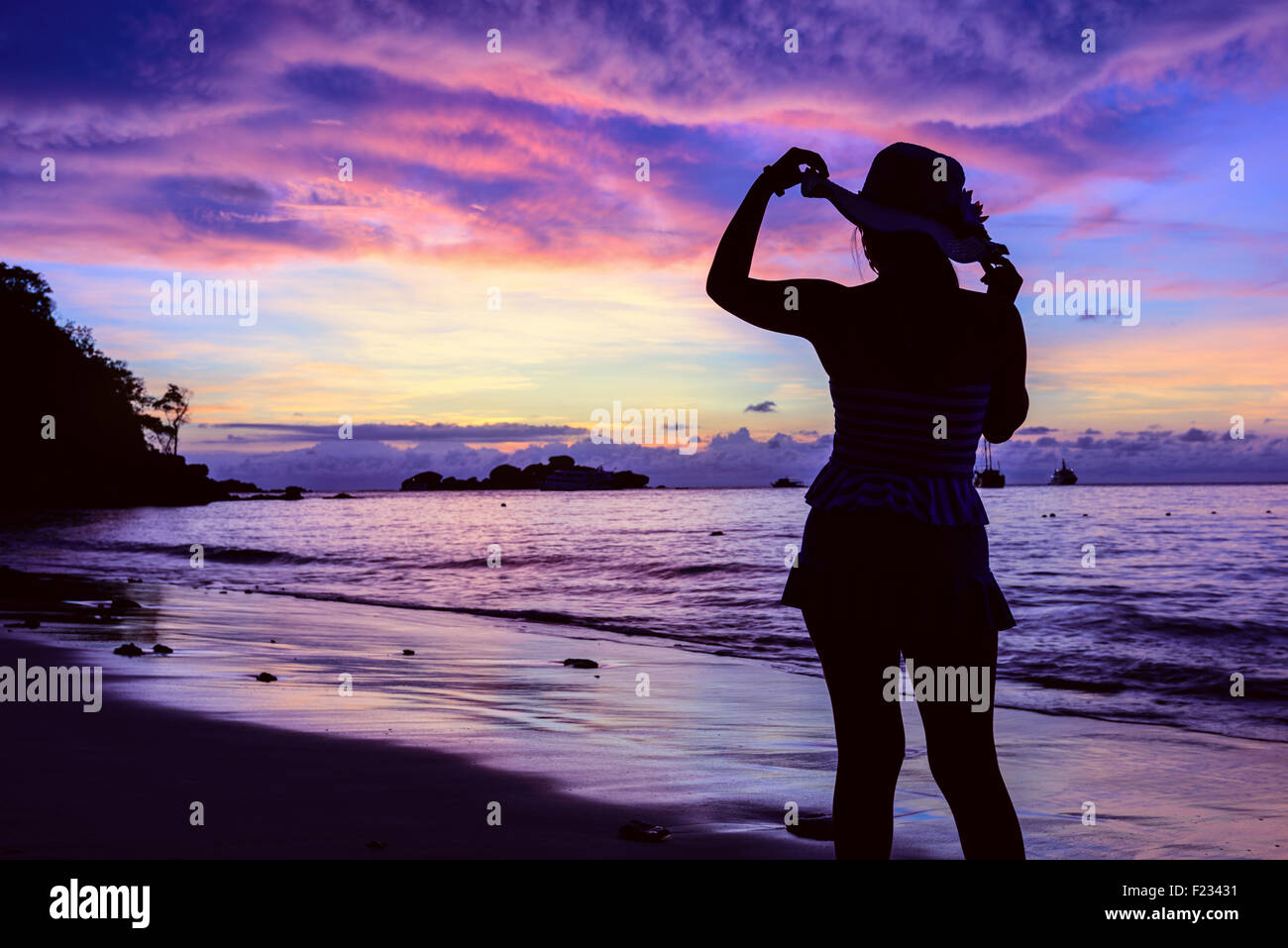 Beau paysage de ciel d'été colorés au lever du soleil, et silhouette fille dans un maillot de pose sur la plage à Miang Banque D'Images