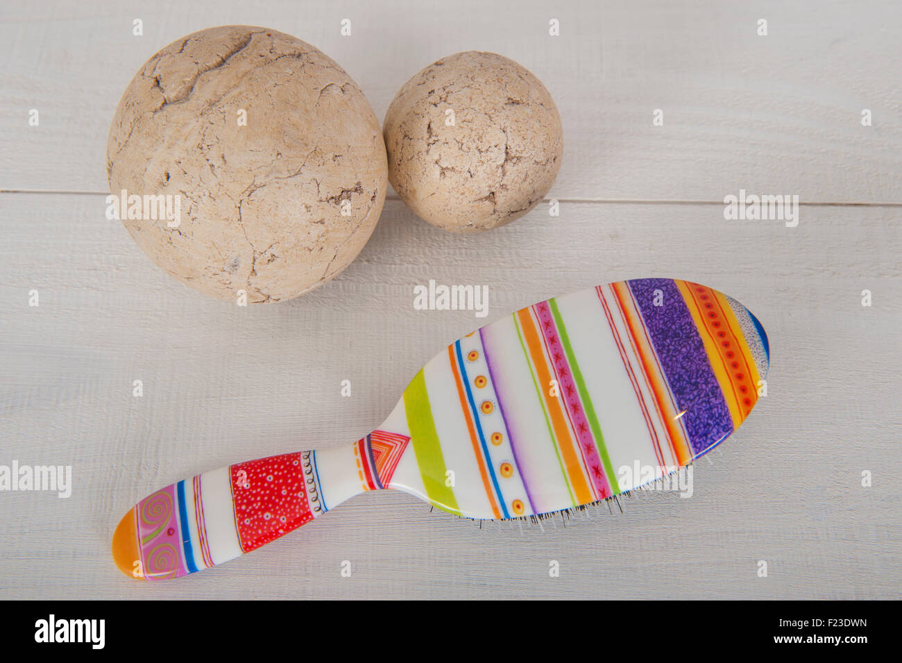 Une brosse à cheveux de couleur vive sur un fond blanc avec deux boules Banque D'Images