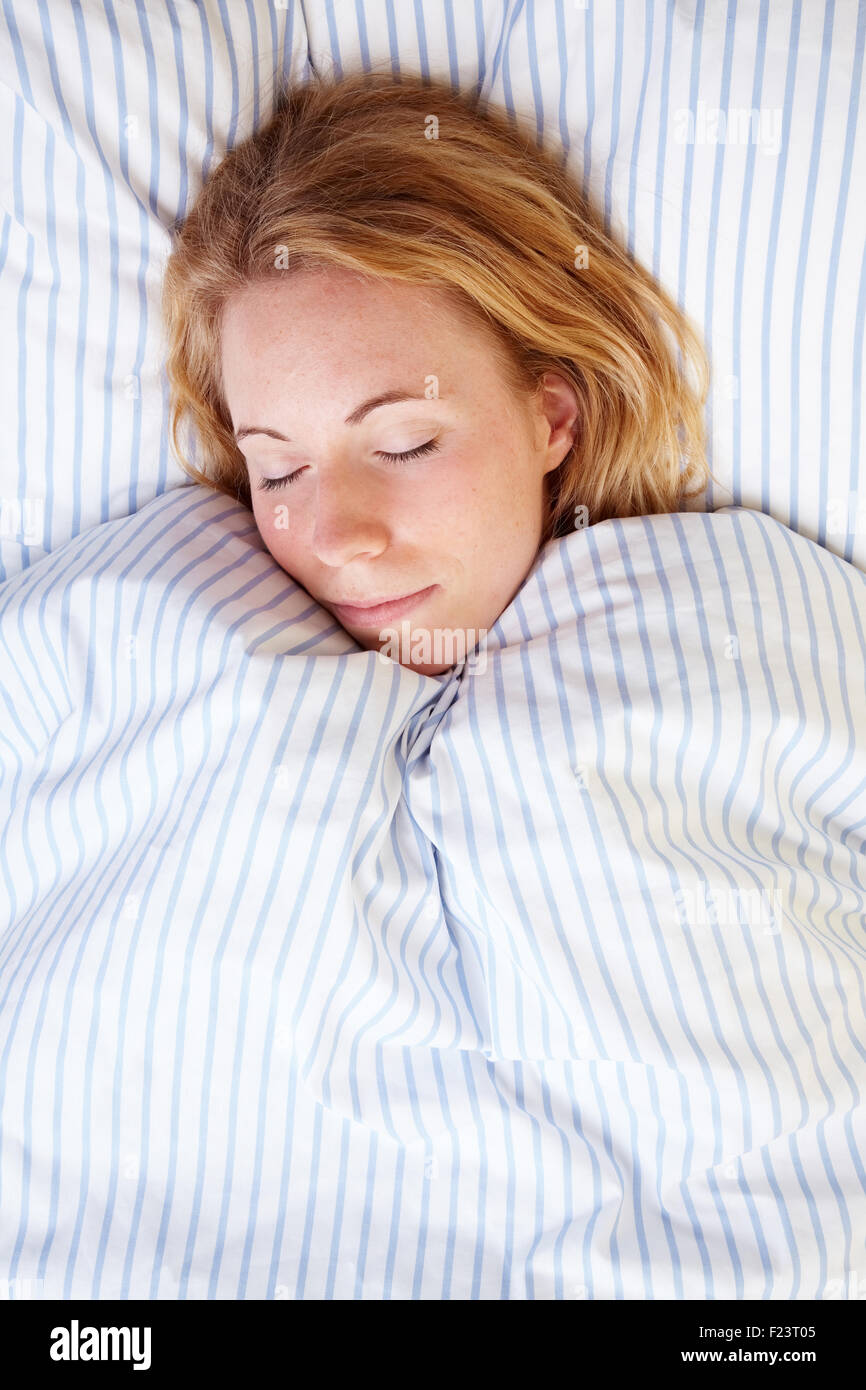 Femme blonde fatigué de dormir dans son lit Photo Stock - Alamy