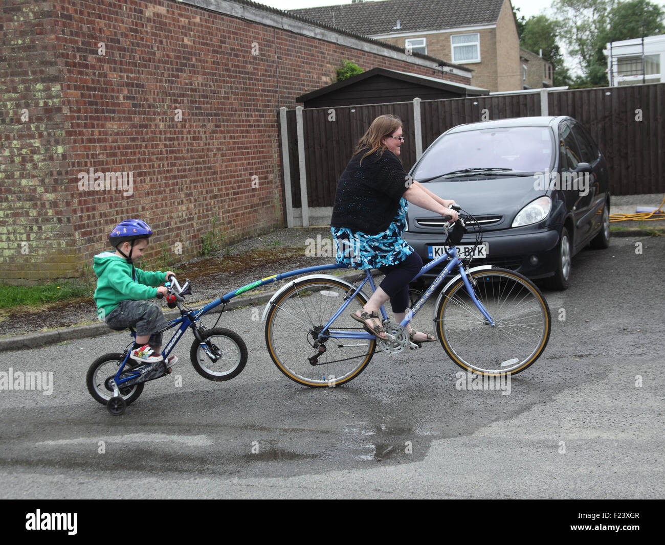 La mère et l'enfant à l'aide de vélo avec trailgator Banque D'Images
