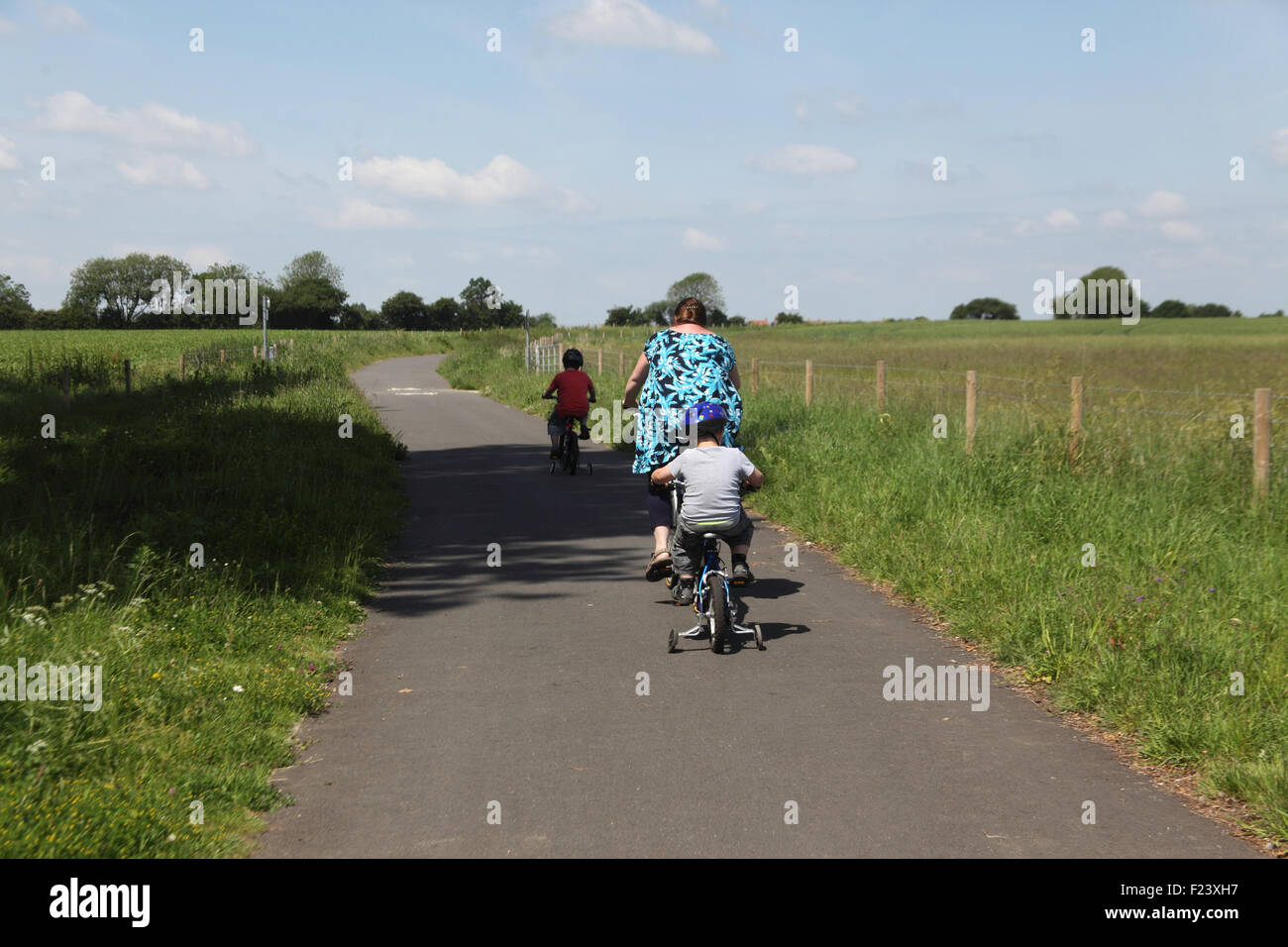 La mère et les enfants faire du vélo sur la piste cyclable de à Watton Norfolk Griston Banque D'Images