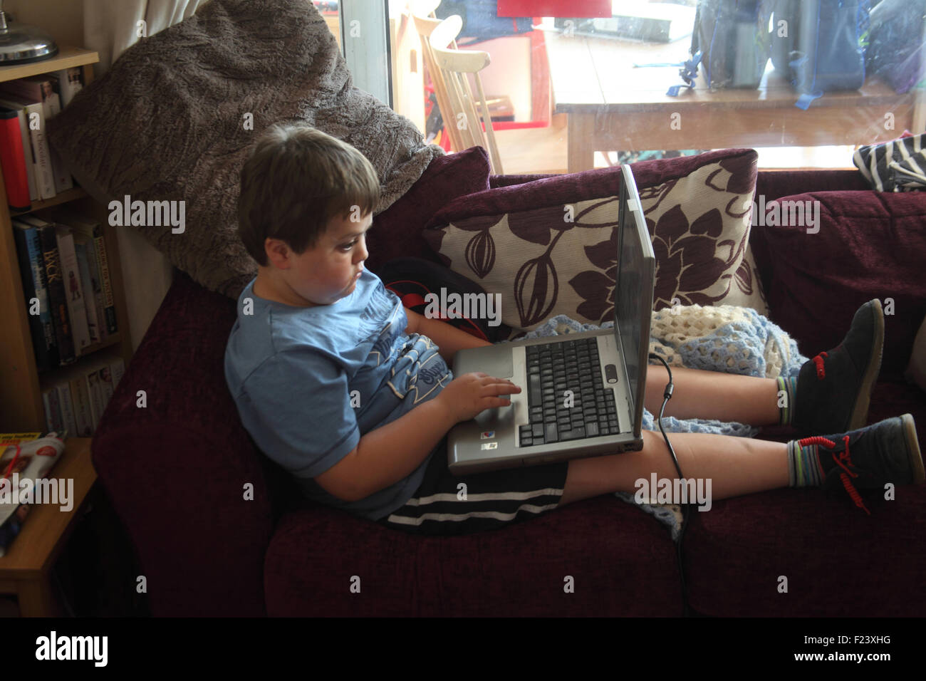 Petit Garçon jouant des jeux vidéo sur ordinateur portable Banque D'Images