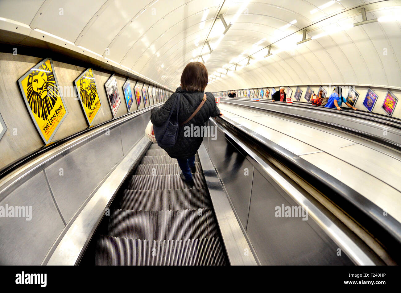 Londres, Angleterre, Royaume-Uni. La station de métro de Londres - femme sur un escalator going down Banque D'Images