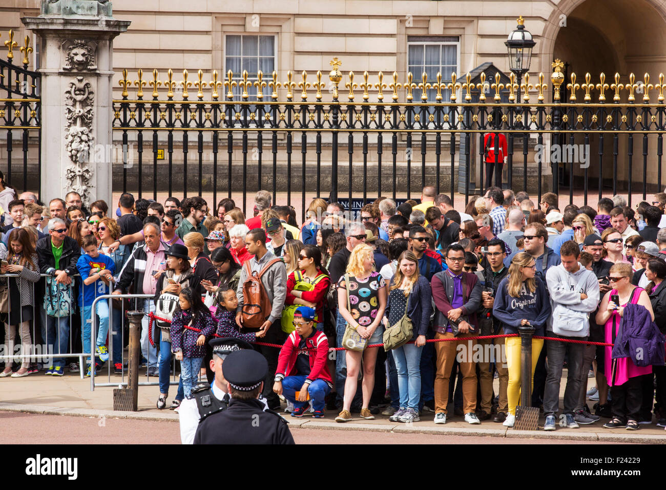 Les touristes à regarder la file d'changeing de la garde à Buckingham Palace, London, UK. Banque D'Images