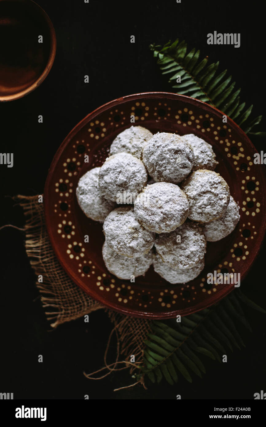 Mariage mexicain cookies affichés sur une plaque de céramique traditionnelle mexicaine sur un fond sombre. Banque D'Images