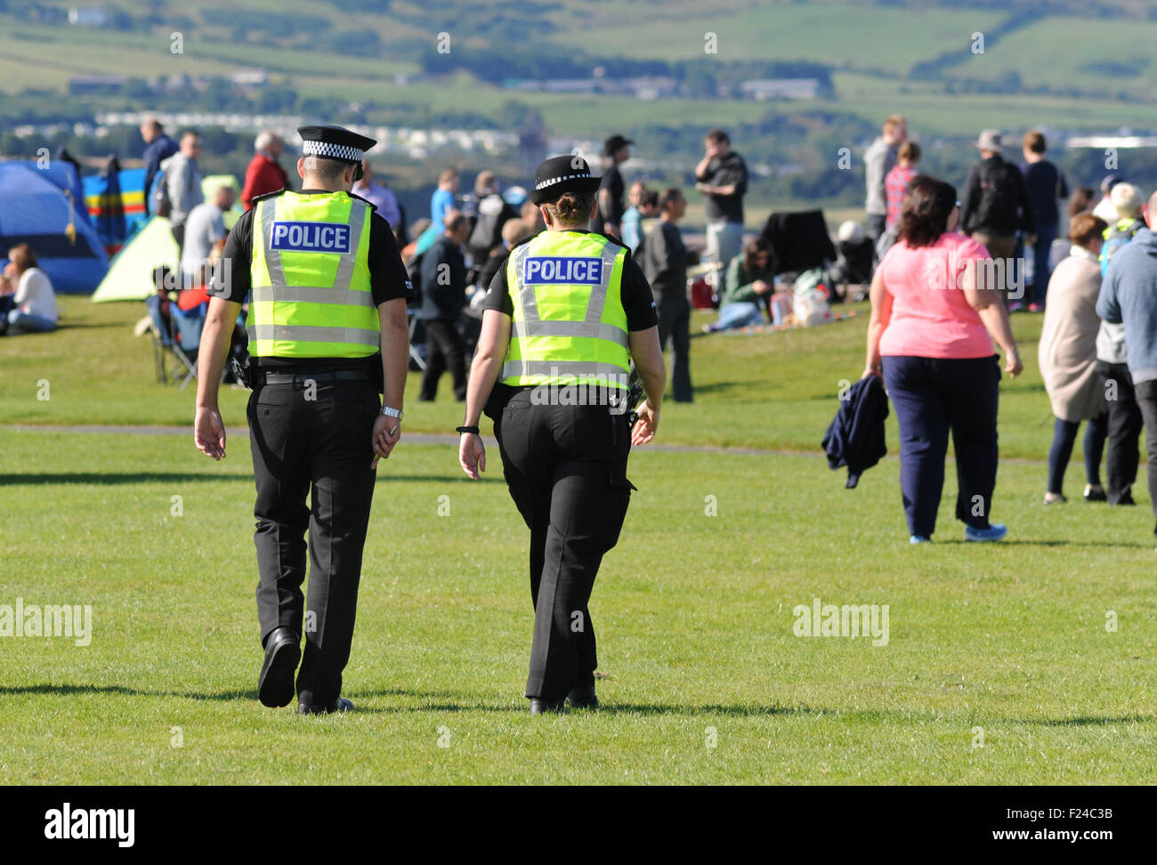 Les agents de police en patrouille à l'ÉVÉNEMENT DE PLEIN AIR POLICE POLICIERS RE FESTIVAL NUMÉROS DES RÉDUCTIONS UNIFORMES MARCHE UK CRIMINEL Banque D'Images