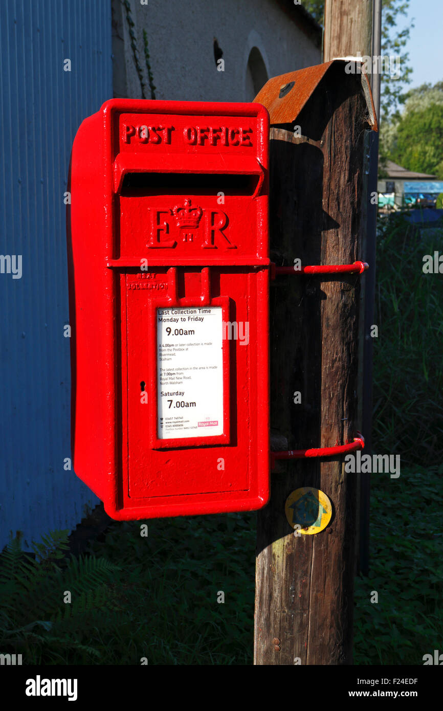 Une boîte aux lettres rouge placé sur un poste par le Staithe à Stalham, Norfolk, Angleterre, Royaume-Uni. Banque D'Images