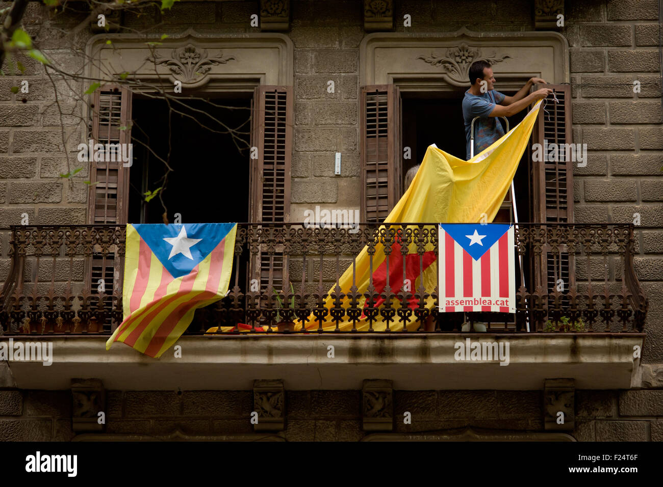 Un homme est un géant (ESTELADA Drapeau indépendantiste catalan) à partir d'un balcon à Barcelone. Banque D'Images