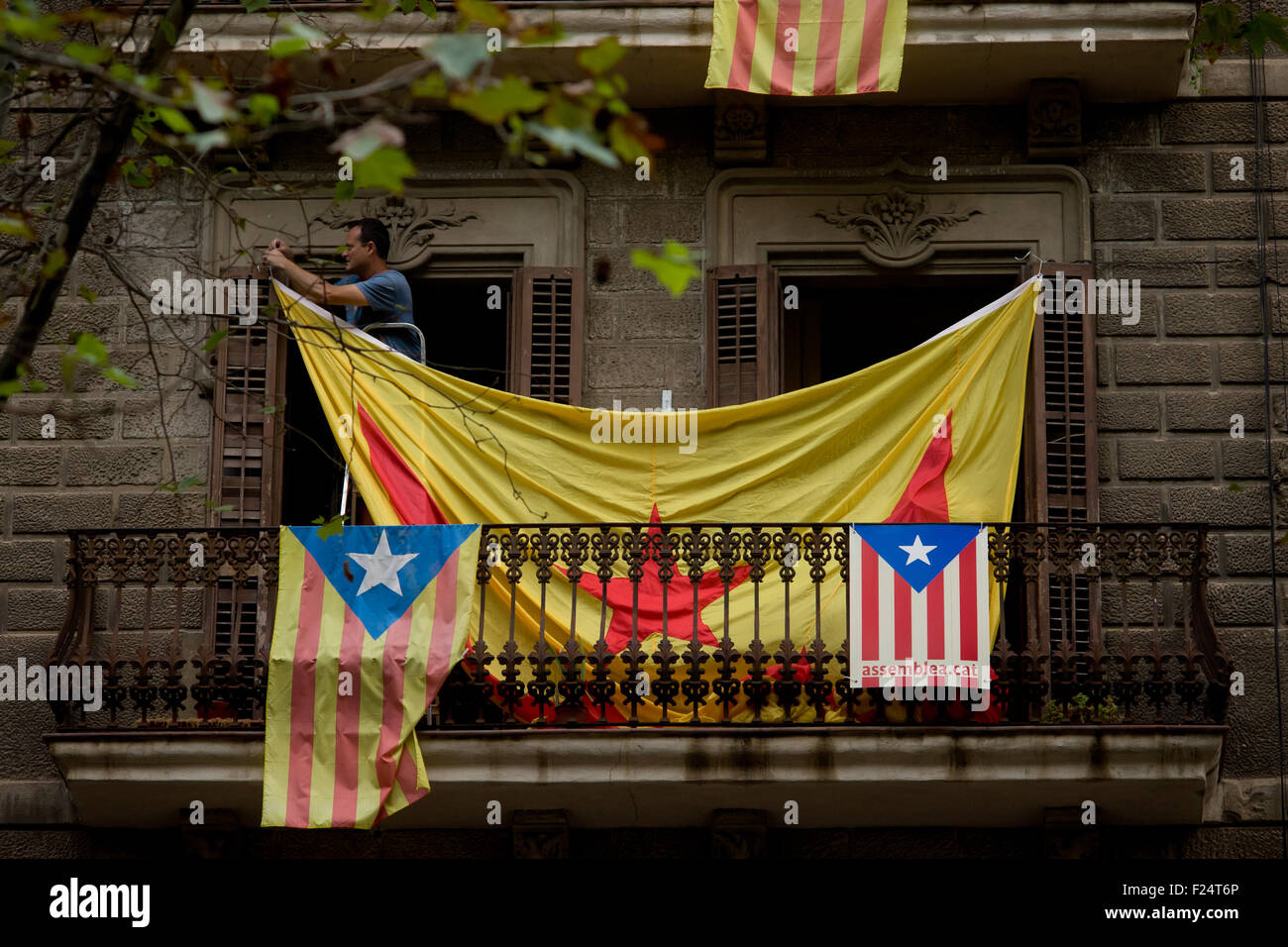 Un homme est un géant (ESTELADA Drapeau indépendantiste catalan) à partir d'un balcon à Barcelone. Banque D'Images