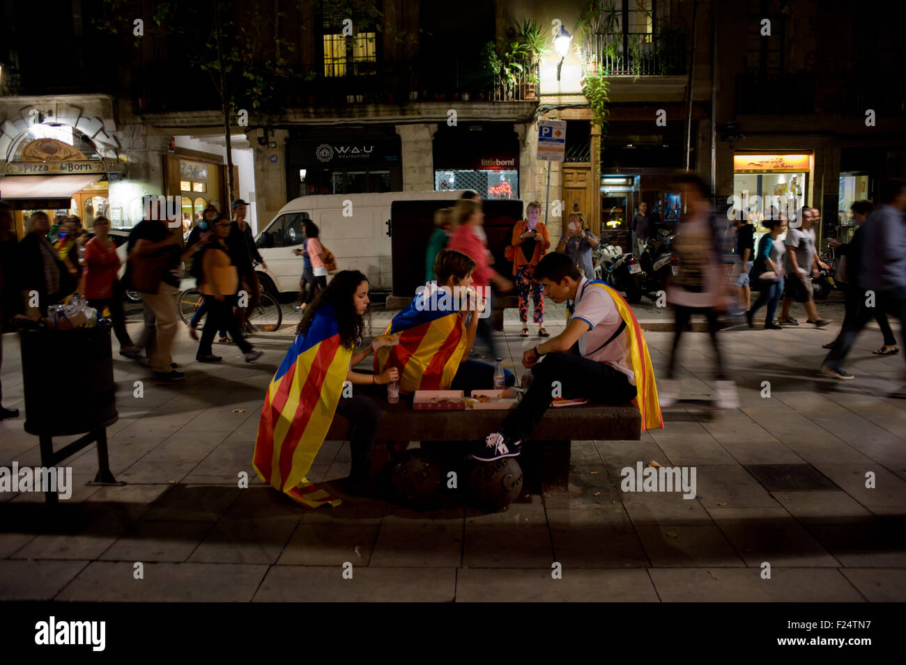 Un groupe de personnes portant un drapeau indépendantiste catalan (estelades) eating pizza dans les rues de Barcelone. Banque D'Images