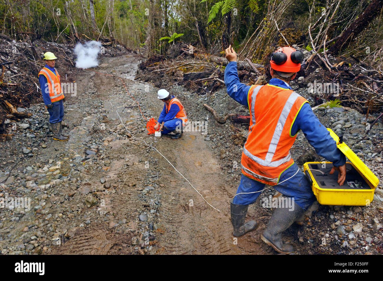 Les hommes partent de charges explosives dans une réflexion sismique à l'enquête de l'huile sur la côte ouest de la Nouvelle-Zélande Banque D'Images
