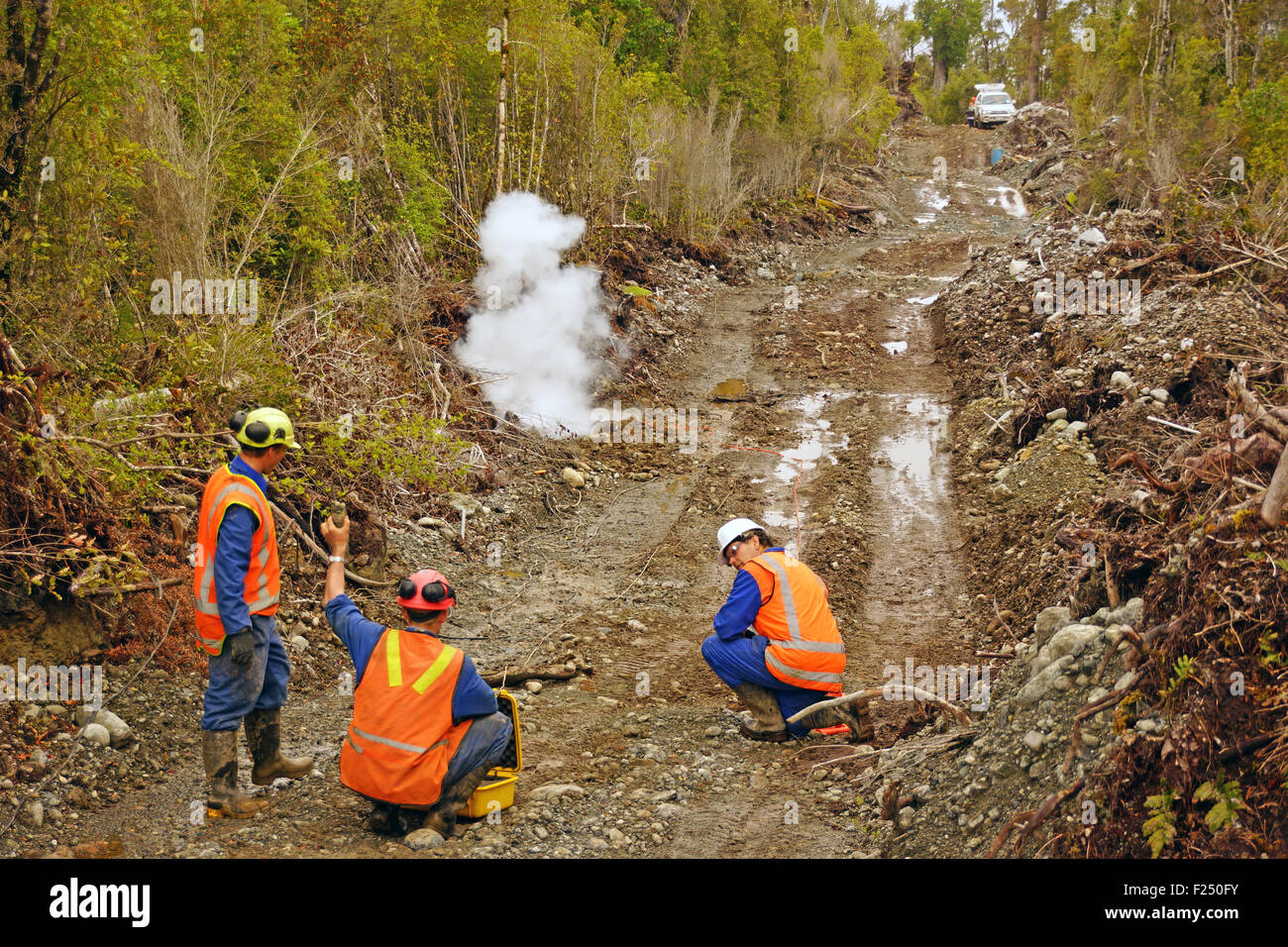 Les hommes partent de charges explosives dans une réflexion sismique sur la côte ouest de la Nouvelle-Zélande. Banque D'Images