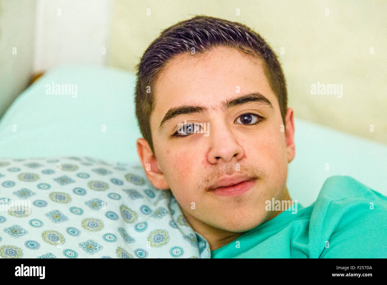 Young Teen boy avec accolades de coussin au lit Banque D'Images