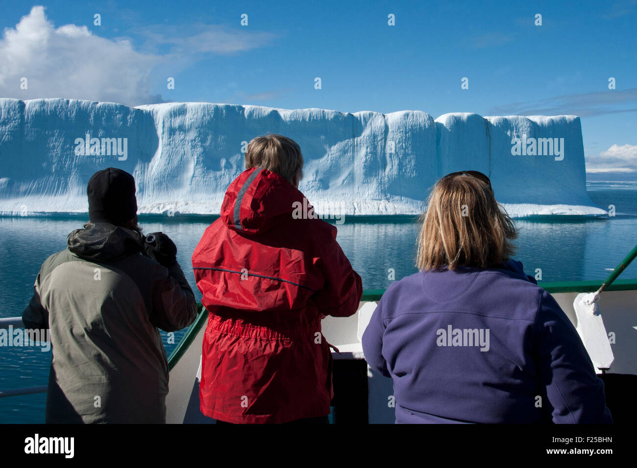 Les éco-touristes regardant un énorme iceberg, près de l'île de Baffin, de l'Arctique canadien Banque D'Images