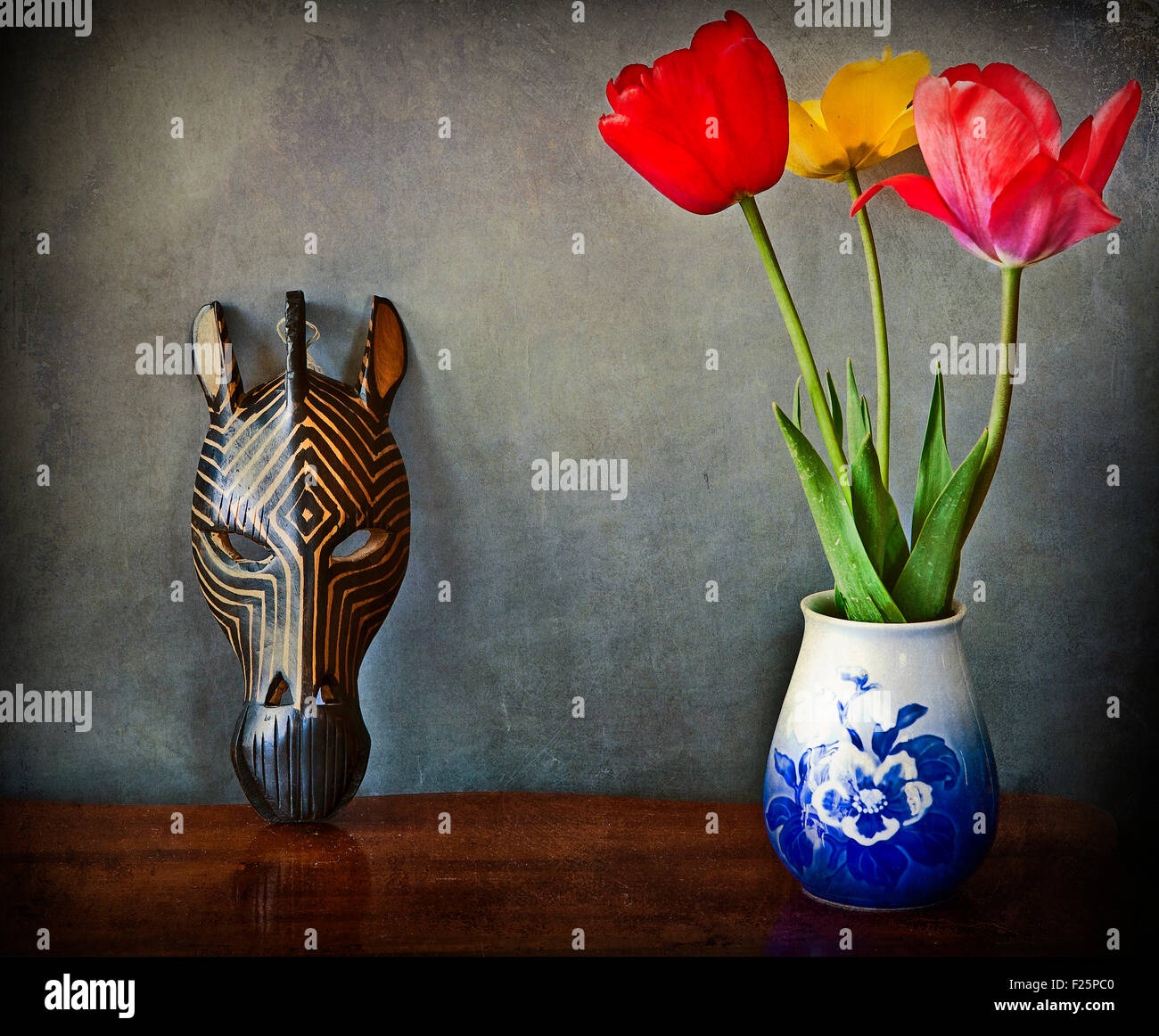 Vintage still life, trois tulipes dans un vase et masque africain en bois Banque D'Images