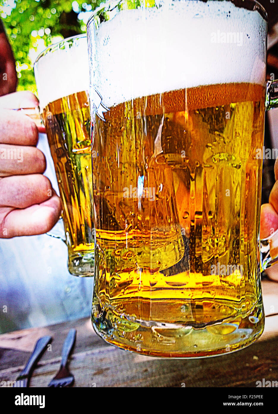 Cheers avec verres, boire de la bière excellente dans l'un des nombreux jardins de la bière à Munich, Allemagne Banque D'Images