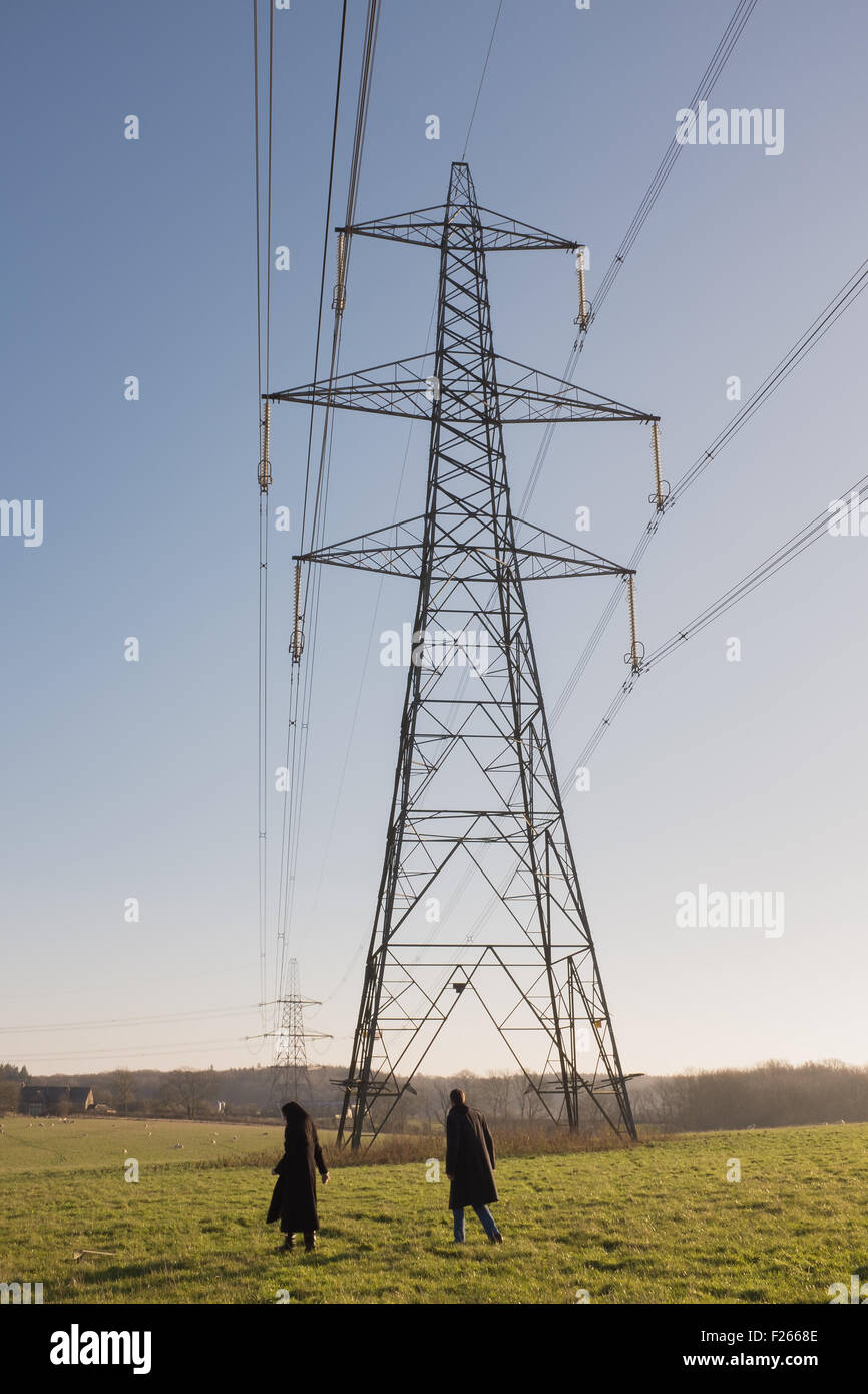 Couple marche près d'un pylône d'électricité Banque D'Images