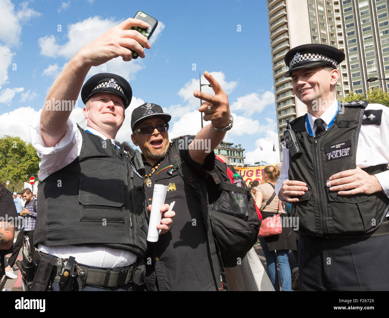 Londres, Royaume-Uni. Sept 12, 2015. Le militant politique Lee Jasper a une prise selfies avec un agent de police. Des dizaines de milliers de personnes prennent part à la solidarité avec les réfugiés de démonstration dans le centre de Londres, David Cameron sur l'appelant à prendre des mesures efficaces pour tourner autour de la crise des réfugiés et accepter la juste part des réfugiés déjà en Europe. D'images éclatantes/Alamy Live News Banque D'Images
