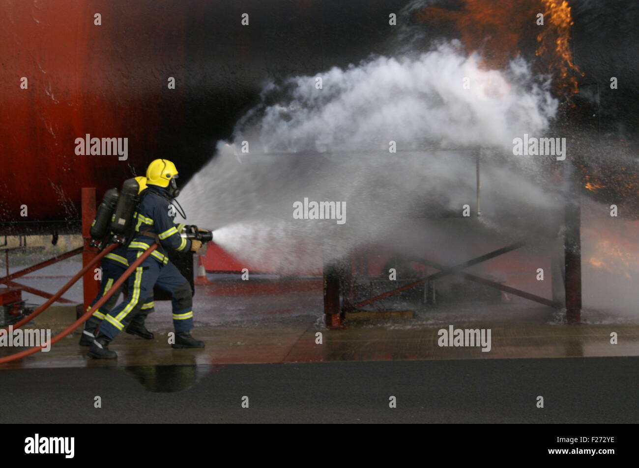 Les pompiers combattre le feu avec le tuyau Banque D'Images