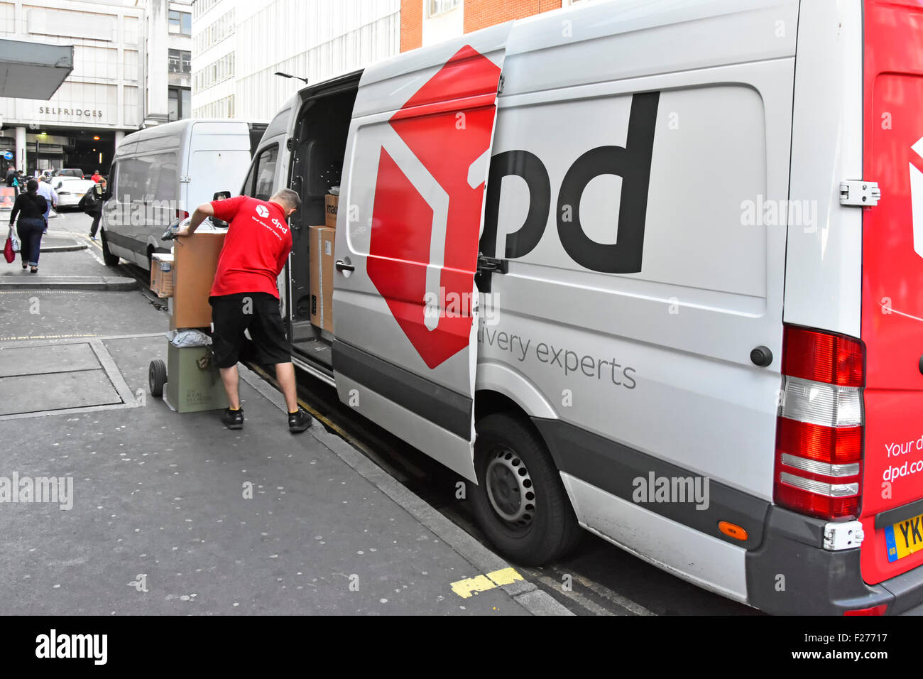 Chauffeur de livraison colis man loading sur chariot de livraison DPD van London England UK Banque D'Images