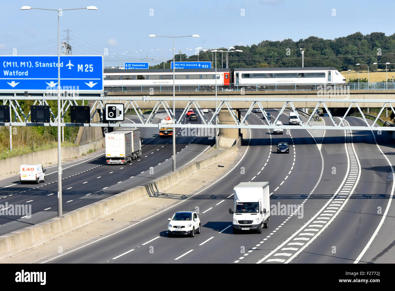 Pont de l'autoroute M25 et une plus grande Anglia inter city train de passagers au-dessus de la jonction de la route 28 à Brentwood Essex England UK Banque D'Images