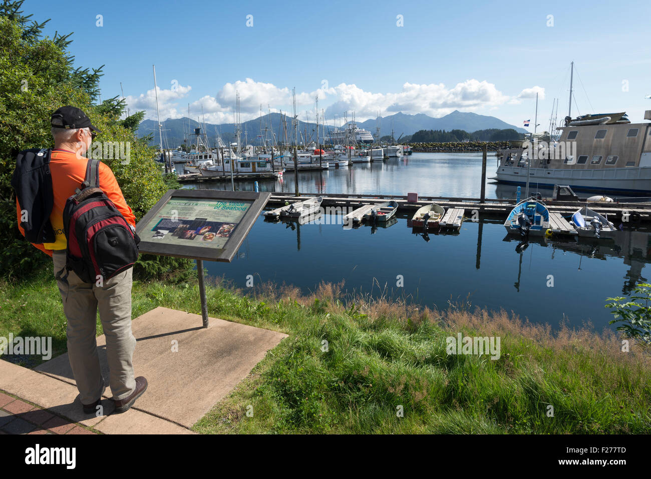 La lecture d'un panneau d'interprétation le long de la mer de Sitka à pied à Sitka, en Alaska. Banque D'Images