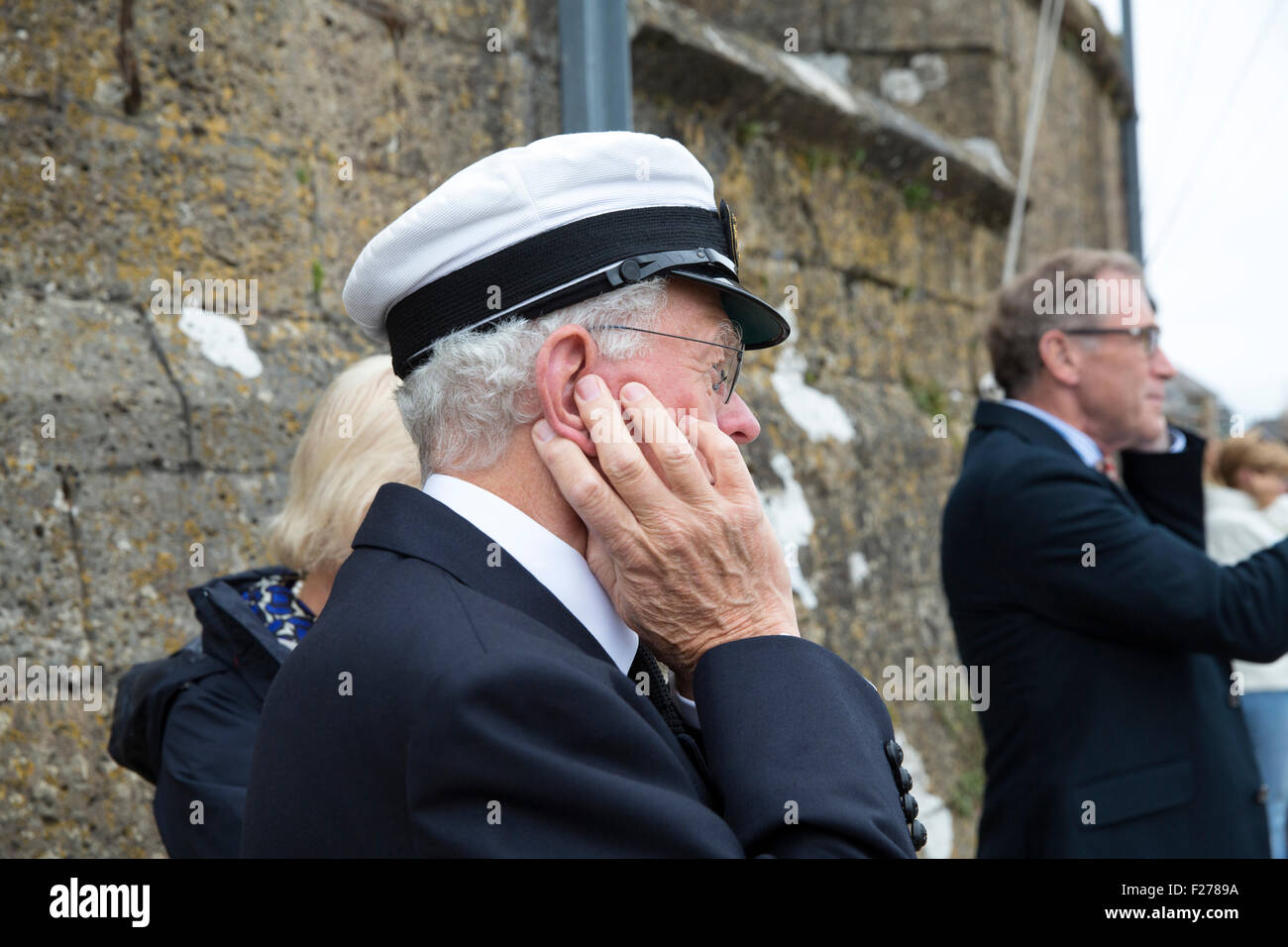 Membre de la Royal Yacht Squadron protège son audition du cannon blast du début de course pendant la semaine de Cowes Banque D'Images