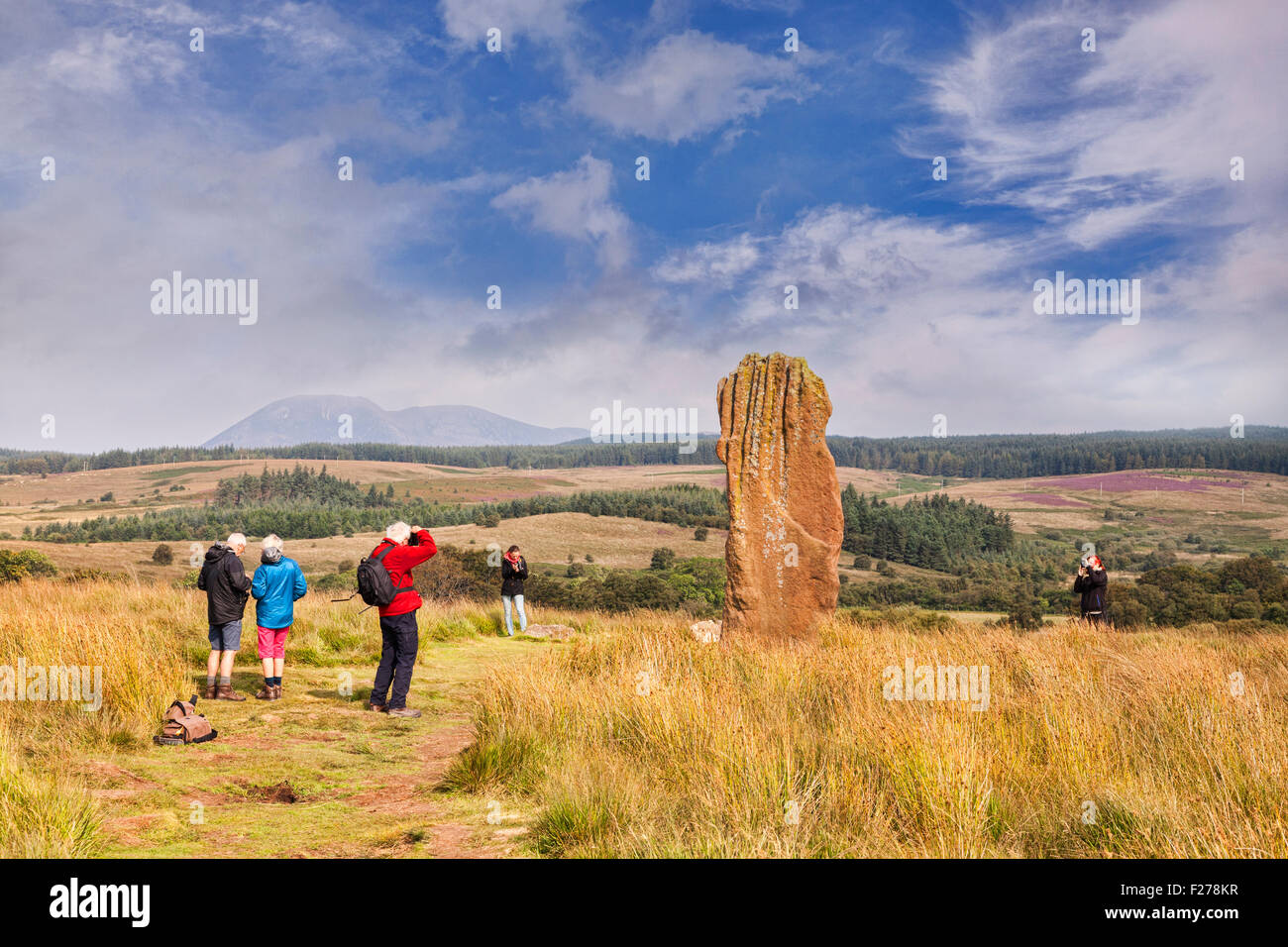 Les touristes de prendre des photos de l'une des pierres sur Machrie Moor, Arran, North Ayrshire, Ecosse. Banque D'Images