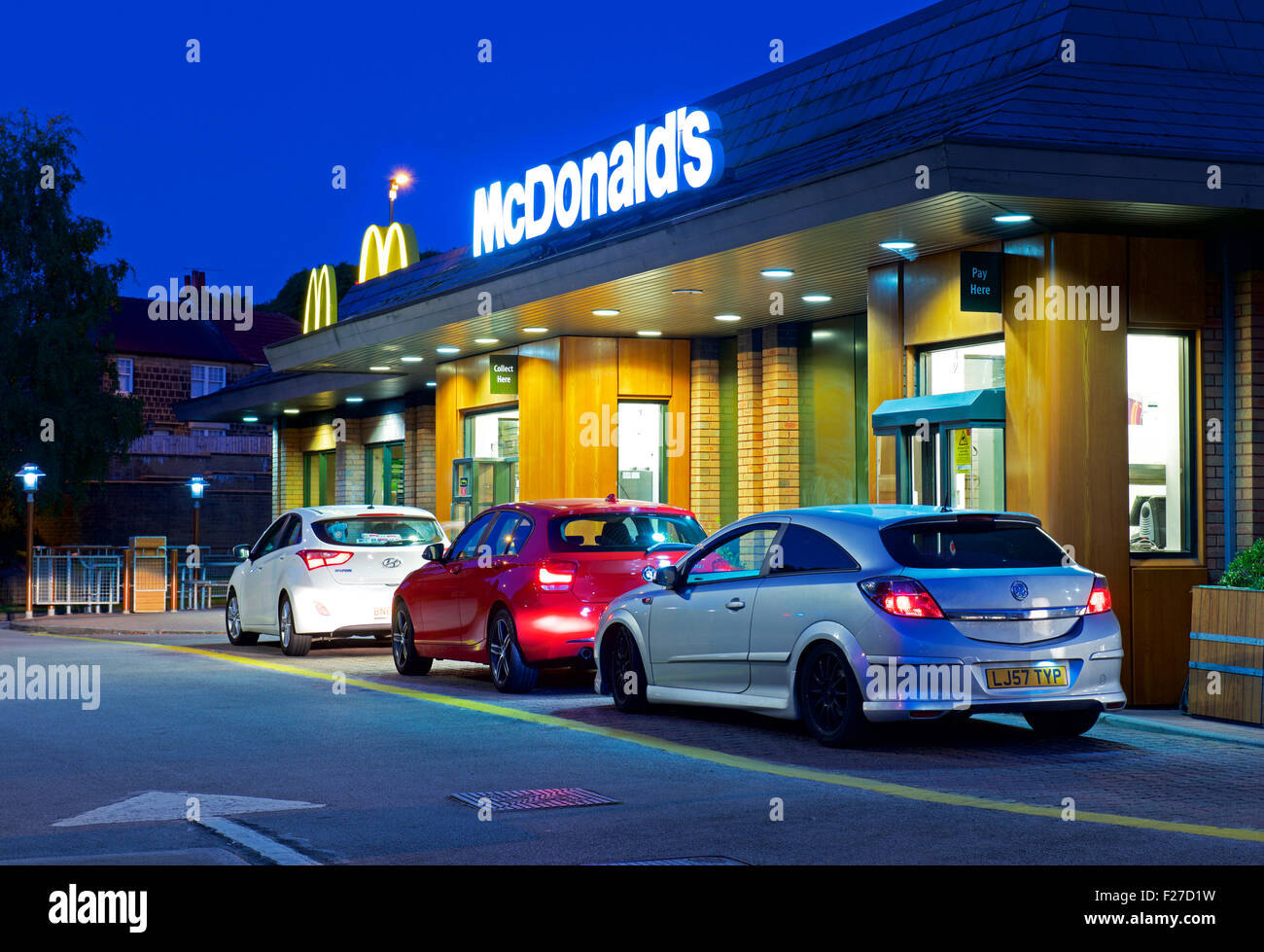 La file de voitures chez McDonald's restaurant drive-in, de nuit, en Angleterre, Royaume-Uni Banque D'Images