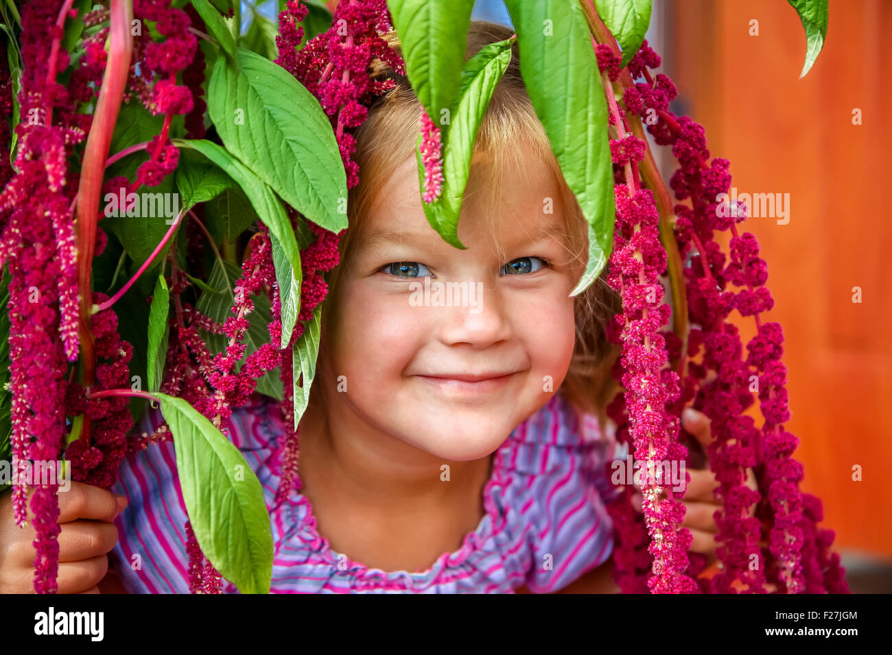 Little girl smiling in fleurs roses Banque D'Images