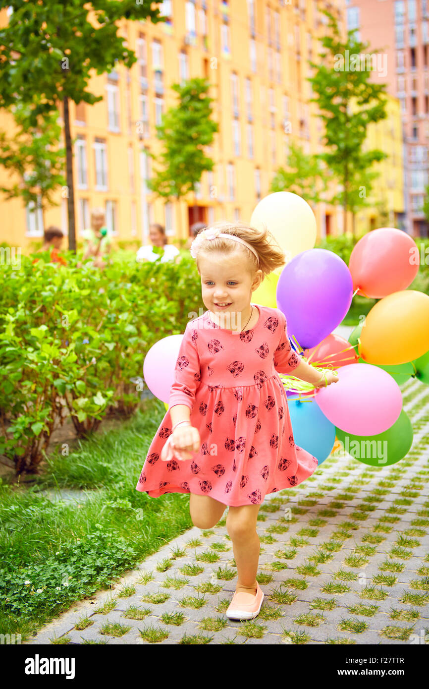 Happy little girl outdoors with balloons Banque D'Images