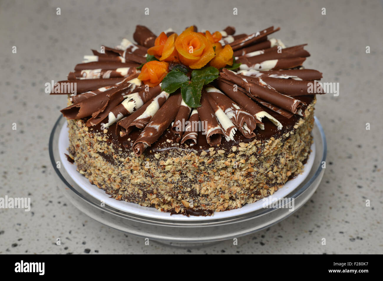 Gâteau au chocolat avec des cacahuètes et décorations rose abricot Banque D'Images