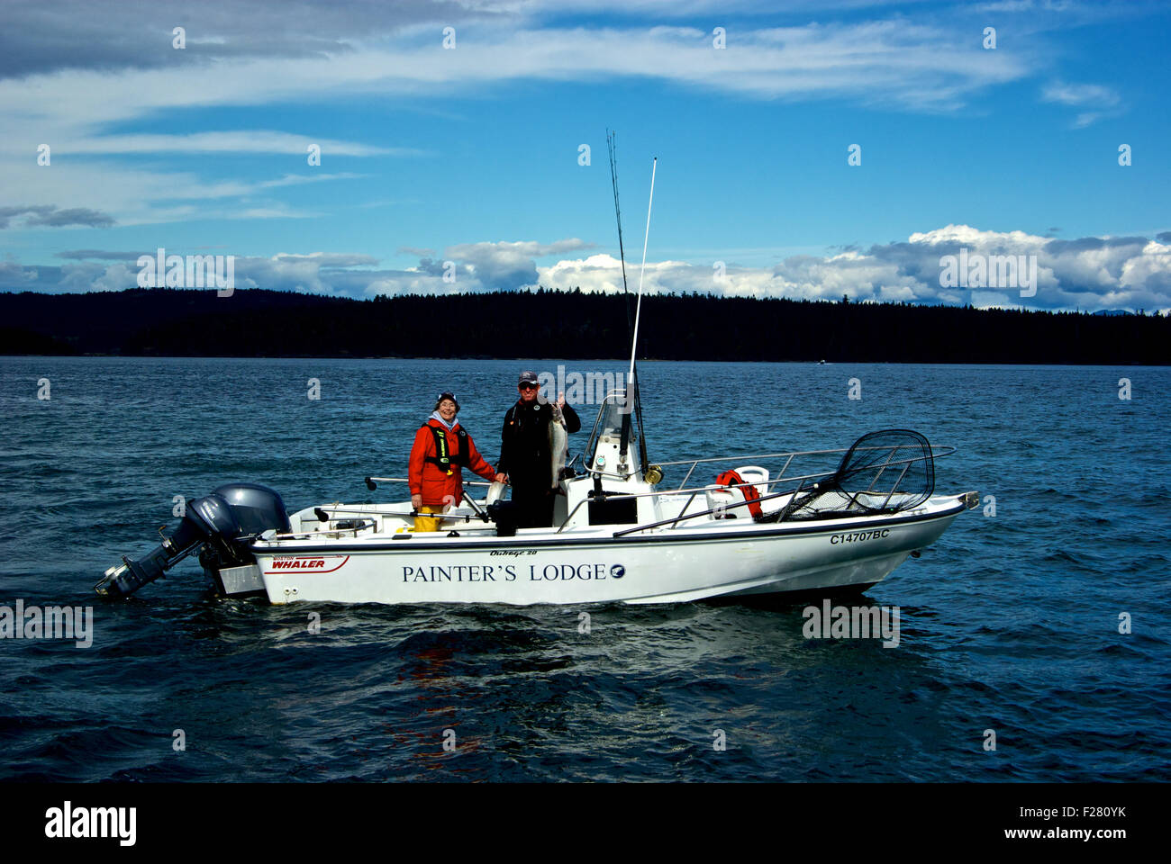 Guide de pêche pêcheur femelle & holding quinnat dans Boston Whaler de 20 pieds de la peinture du bateau indignation Lodge Campbell River (Colombie-Britannique). Banque D'Images