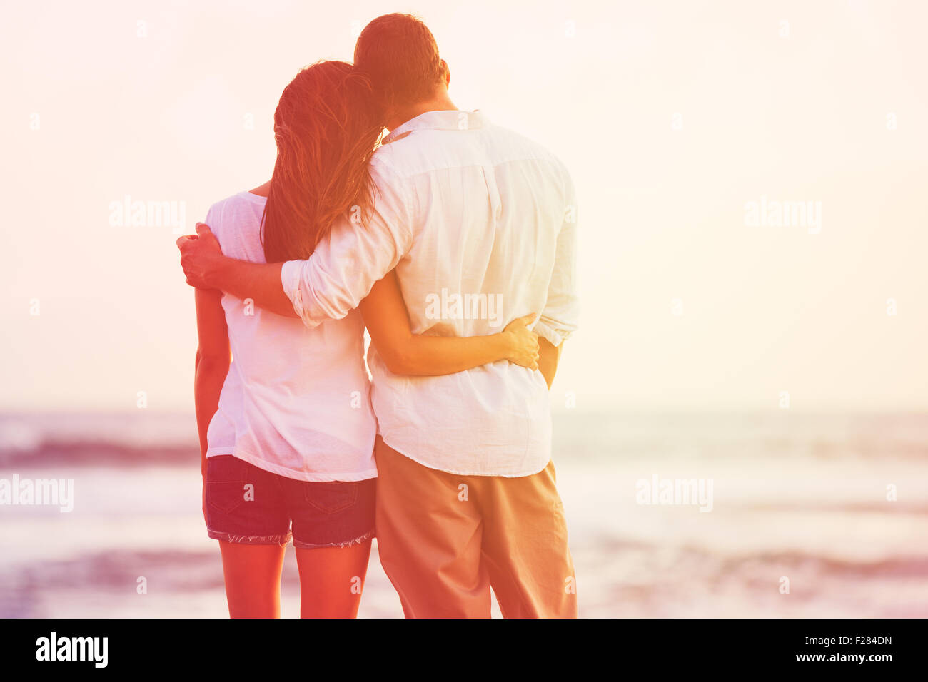 Happy Romantic Couple Enjoying beau coucher de soleil sur la plage Banque D'Images