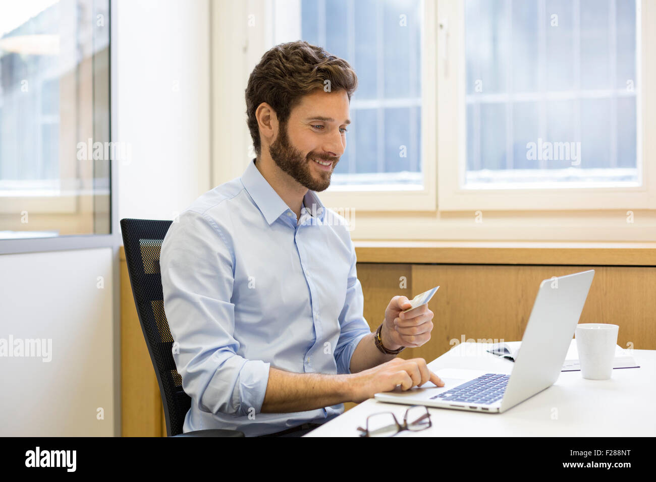 L'homme d'affaires occasionnels de payer en ligne par carte de crédit. Banque D'Images
