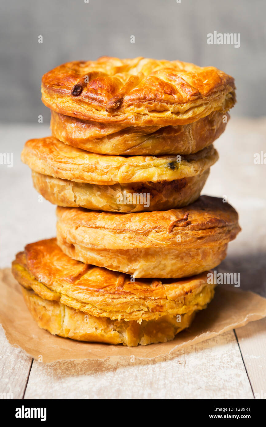 Une pile de pâtés à la viande fait maison sur une table rustique. Banque D'Images