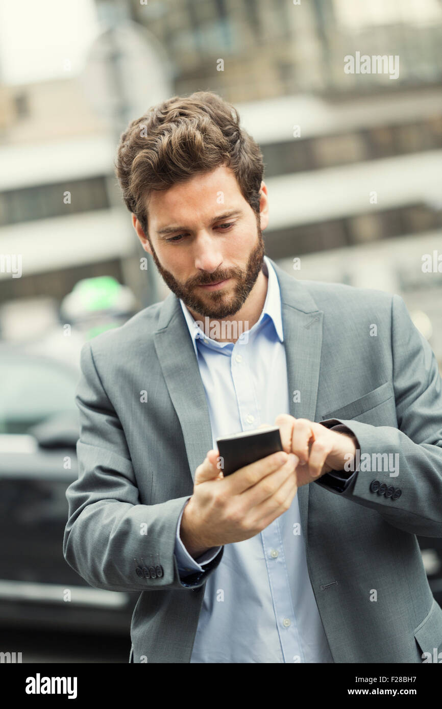 L'homme commande un taxi à partir de son téléphone mobile Banque D'Images