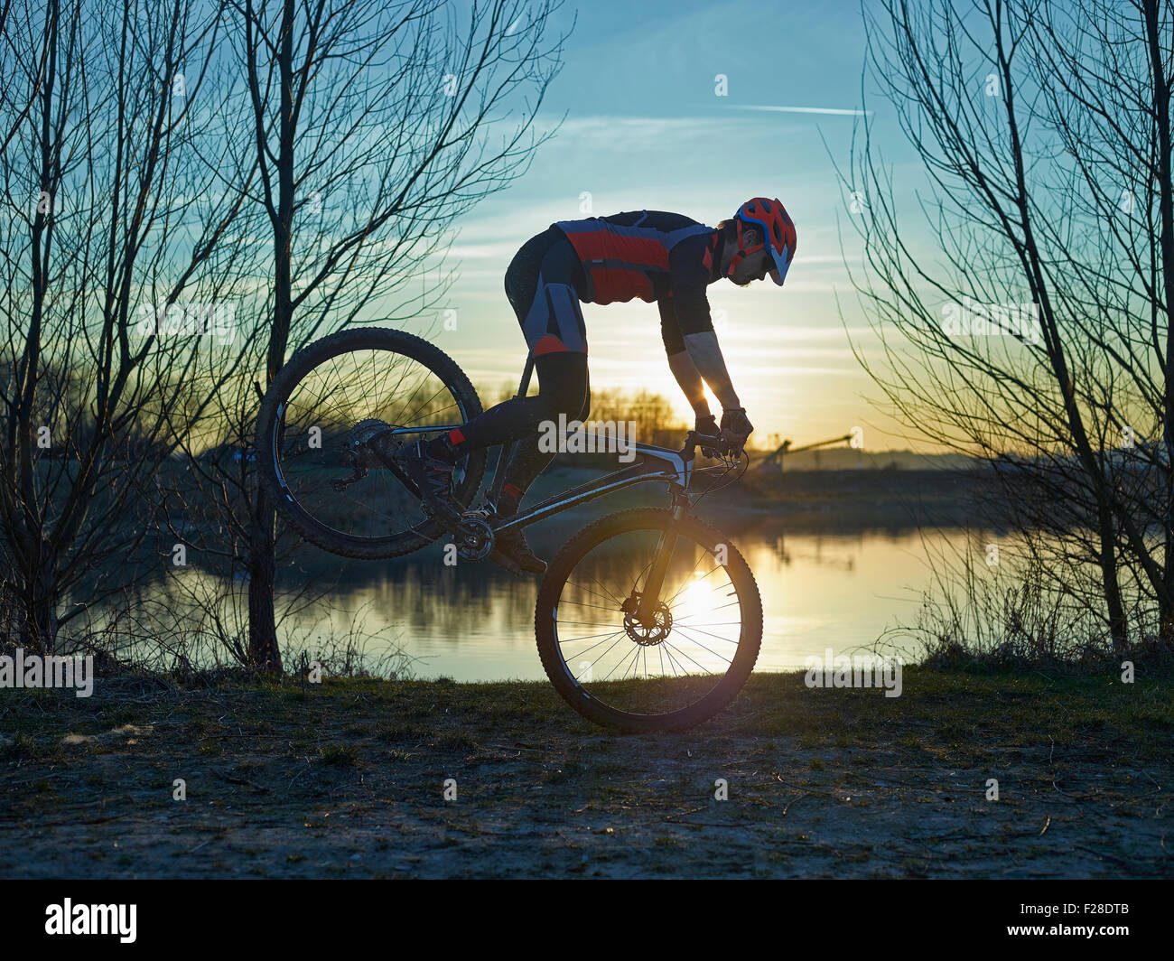 Young cascades sur vtt durant le coucher du soleil, Bavière, Allemagne Banque D'Images