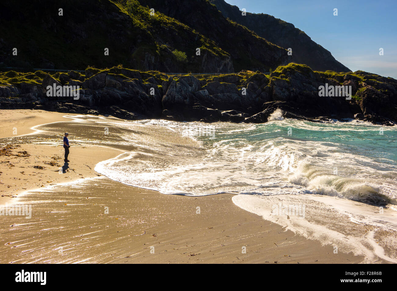 Petite figure solitaire sur grosse vague plage lavés, Andoya, Norvège Banque D'Images