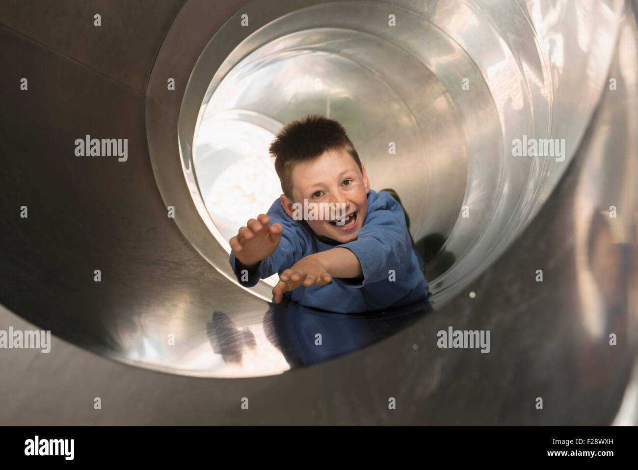 Garçon coulissant dans un tunnel glisse, Munich, Bavière, Allemagne Banque D'Images
