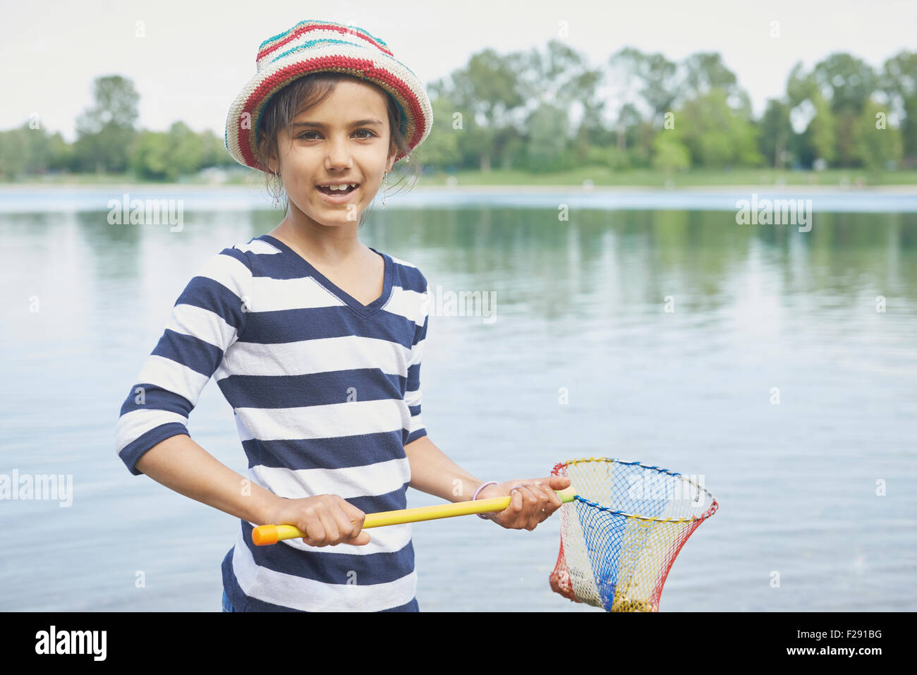 Girl holding stones en filet de pêche, Bavière, Allemagne Banque D'Images
