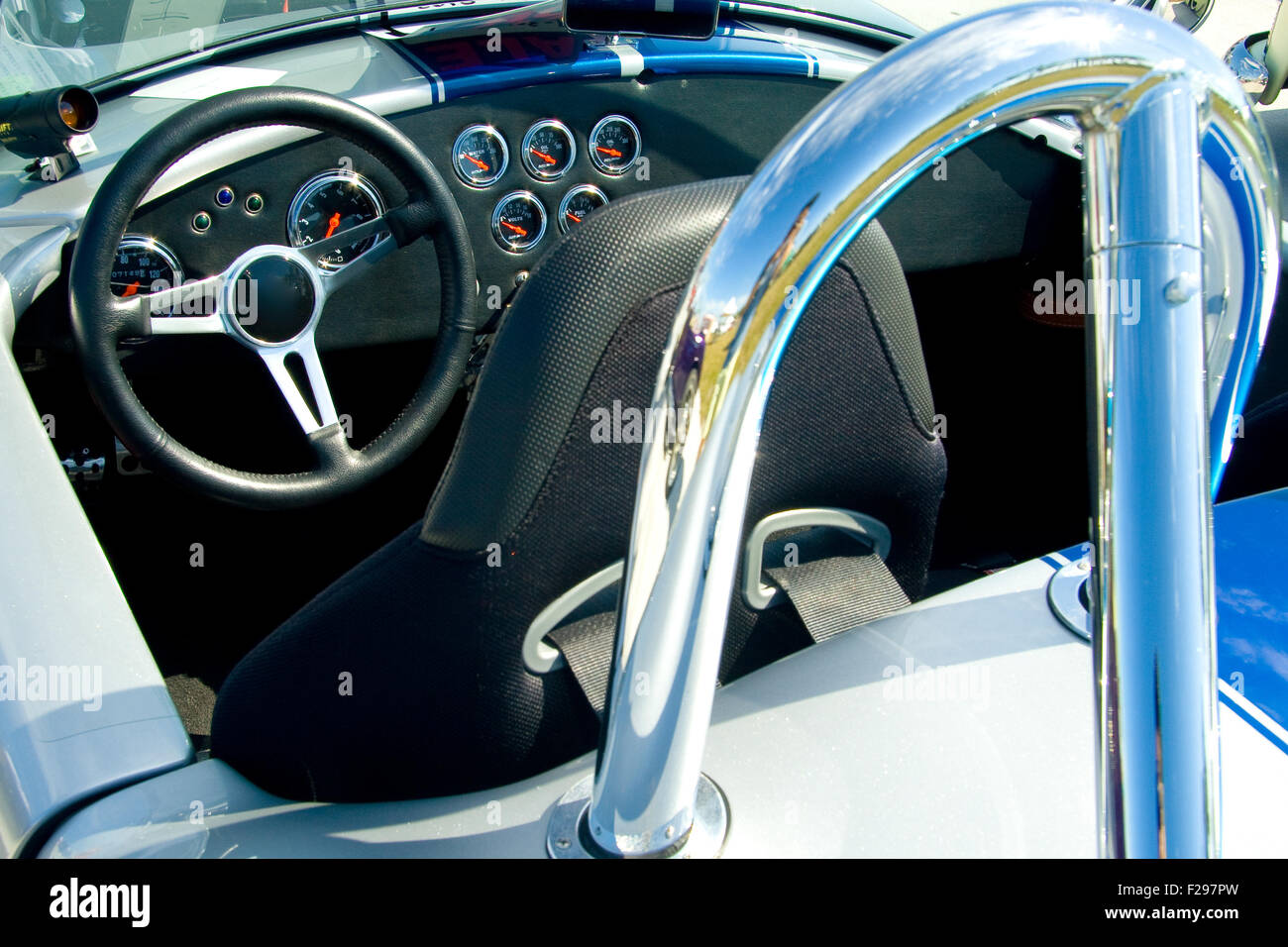 Intérieur d'une voiture de sport vintage montrant volant, tableau de bord, siège conducteur et dispositif de protection. Banque D'Images