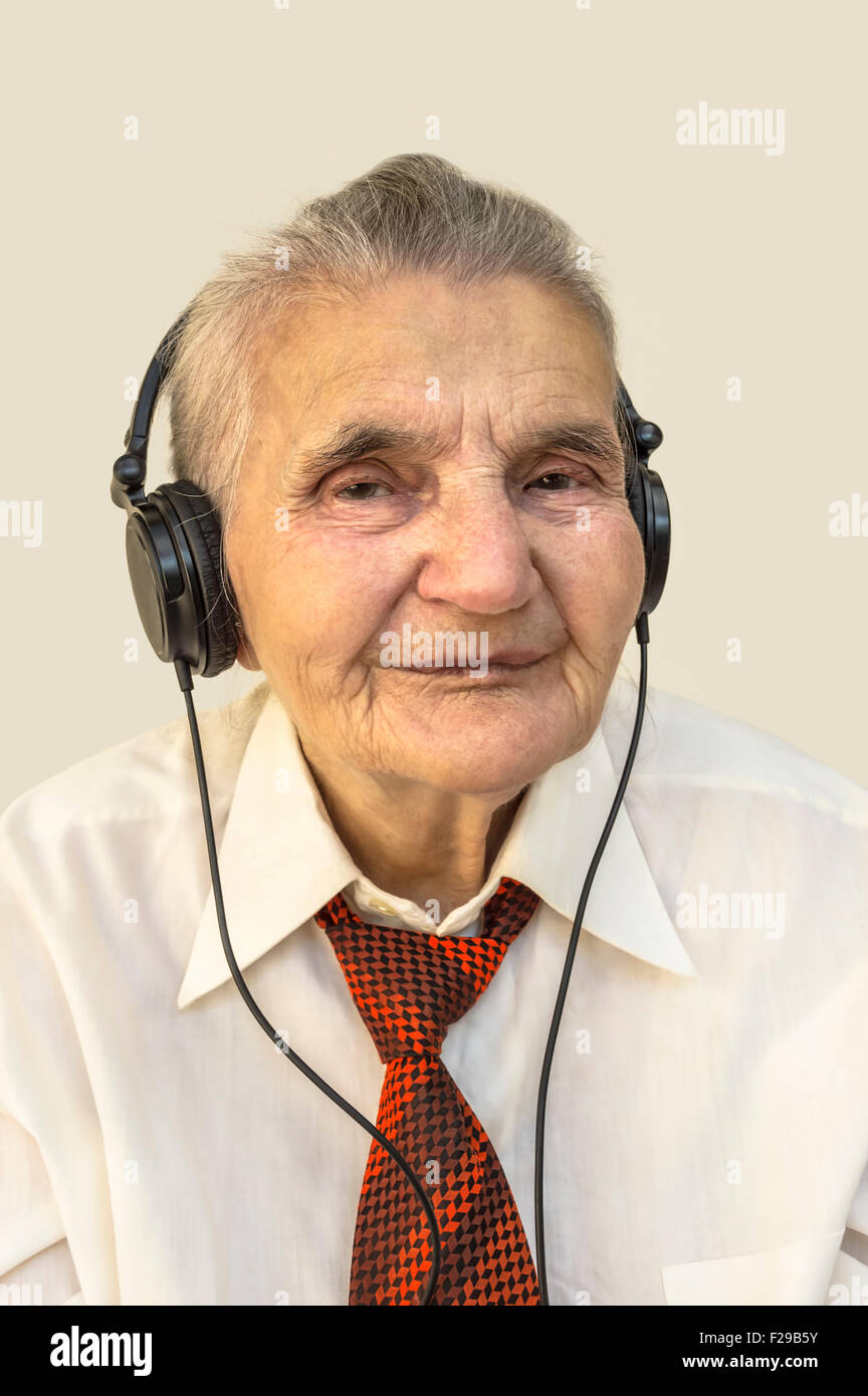 Femme âgée avec des écouteurs pour écouter de la musique. Banque D'Images
