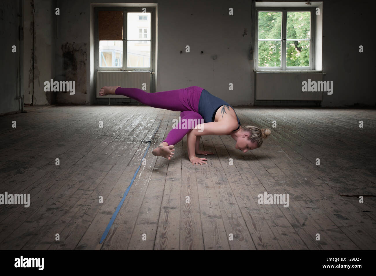 Mid adult woman practicing Eka pada koundinyasana je pose dans un studio de yoga, Munich, Bavière, Allemagne Banque D'Images