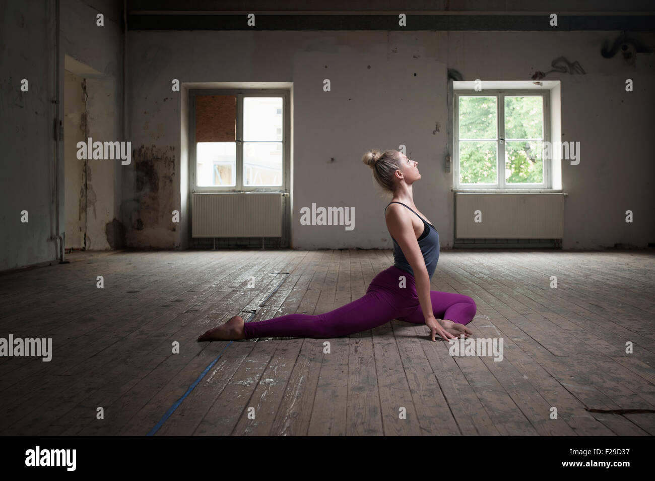 Mid adult woman in yoga studio posent pigeon, Munich, Bavière, Allemagne Banque D'Images