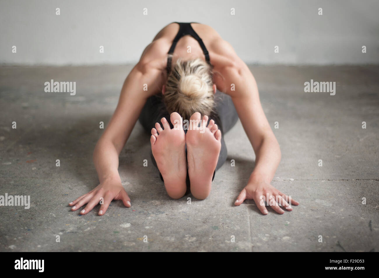 Mid adult woman practicing assis flexion avant de poser dans un studio de yoga, Munich, Bavière, Allemagne Banque D'Images