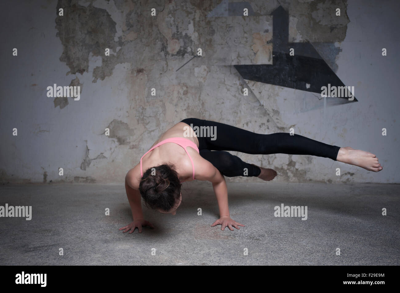 Mid adult woman practicing parsva bakasana pose dans un studio de yoga, Munich, Bavière, Allemagne Banque D'Images