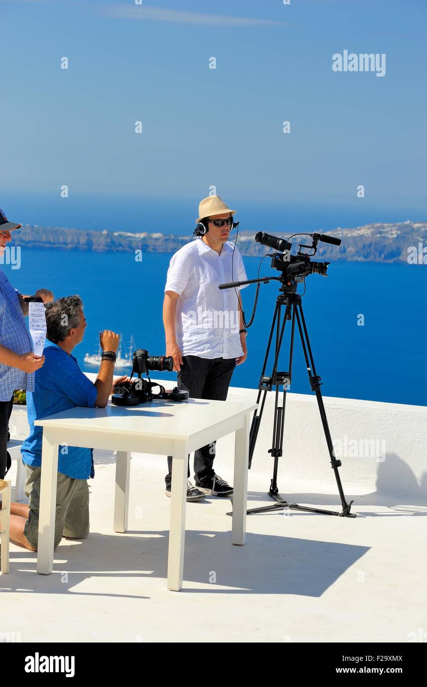 Un homme portant un chapeau de soleil en utilisant une caméra vidéo sur un trépied sur l'île de Santorini Grèce Banque D'Images